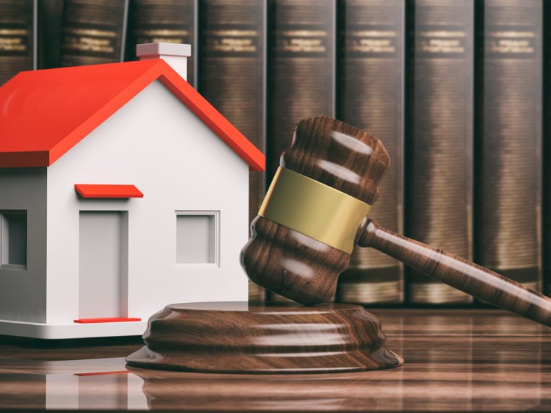 Wooden judge or auction gavel, a small house and books. 3d illustration
